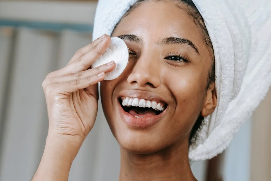 A woman cleansing her face.