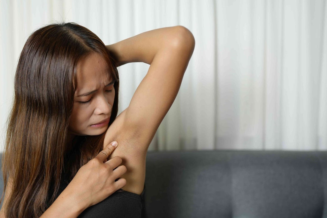A woman looking at her armpit skin.
