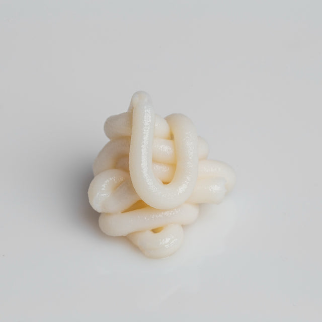 A coil of Roon's balm holding its shape on a white surface