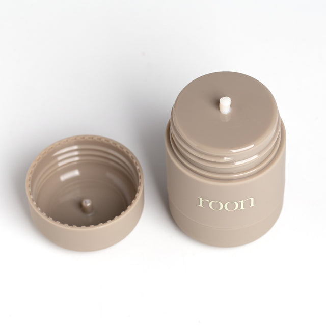 A Roon tube with its cap removed, showing the dense balm sitting flush in the twist-up applicator